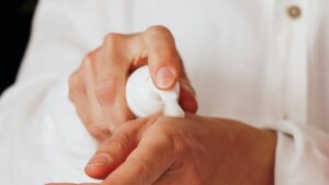 Persoon brengt crème aan op de hand voor huidverzorging gericht op littekens verminderen